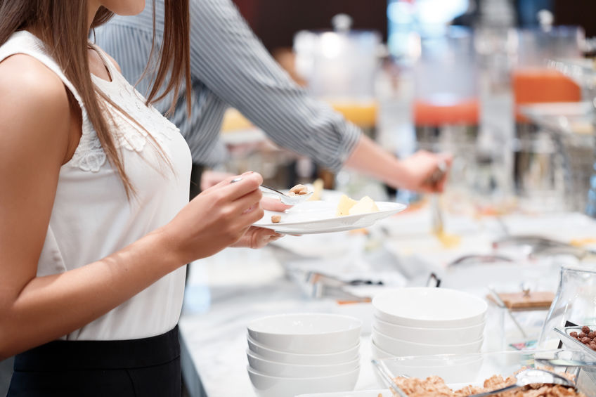 Woman looking at a buffet catering line at a corporate event